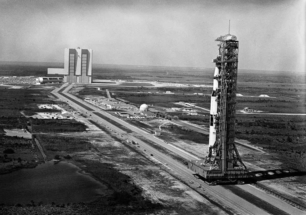 NASA rocket hanger in background with rocket and launch pad in foreground