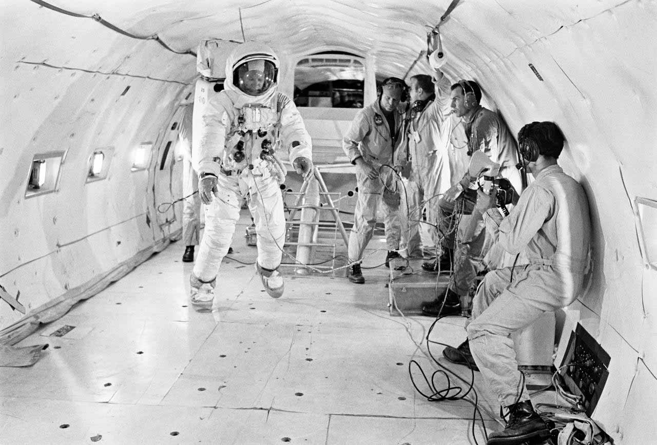NASA astronaut testing suit with technicians in the 1960s